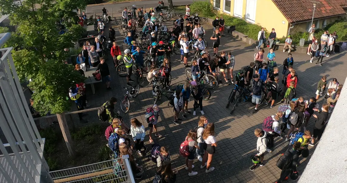 Eine große Menge Schüler steht im Schulhof des Gymnasiums nachdem sie am Tag der Sternfahrten an der Schule angekommen sind.